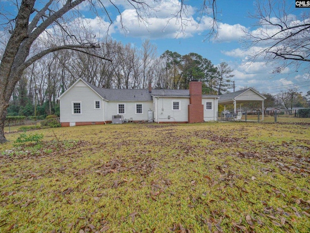 back of house featuring central AC, a lawn, and a carport