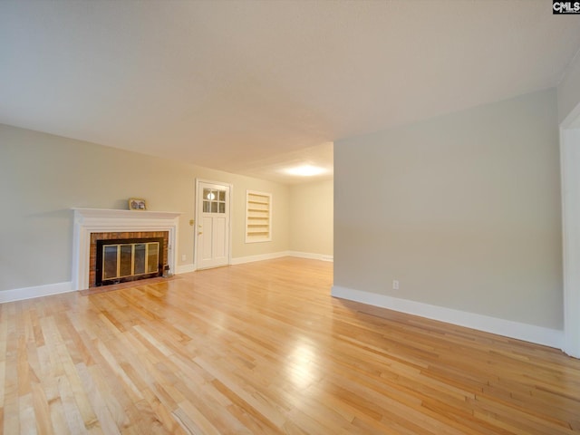 unfurnished living room with built in features and light hardwood / wood-style flooring