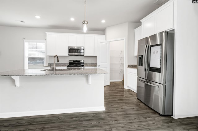 kitchen featuring stainless steel appliances, a kitchen island with sink, white cabinets, and sink