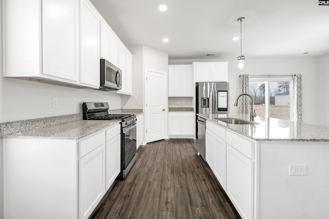 kitchen featuring sink, white cabinetry, hanging light fixtures, light stone countertops, and appliances with stainless steel finishes