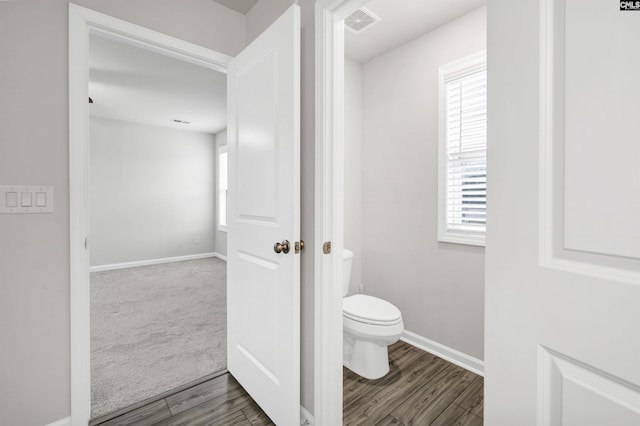 bathroom featuring toilet, a wealth of natural light, and wood-type flooring