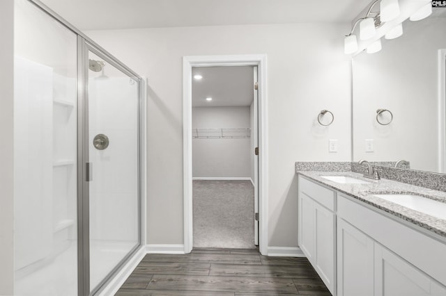 bathroom with a shower with door, hardwood / wood-style floors, and vanity