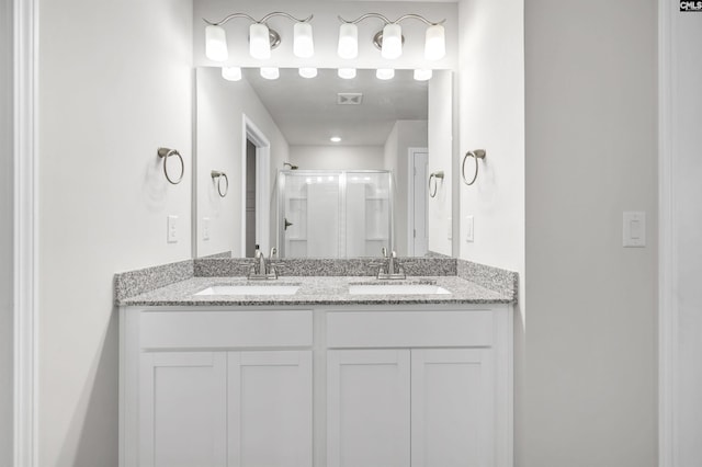 bathroom featuring vanity and a shower with shower door