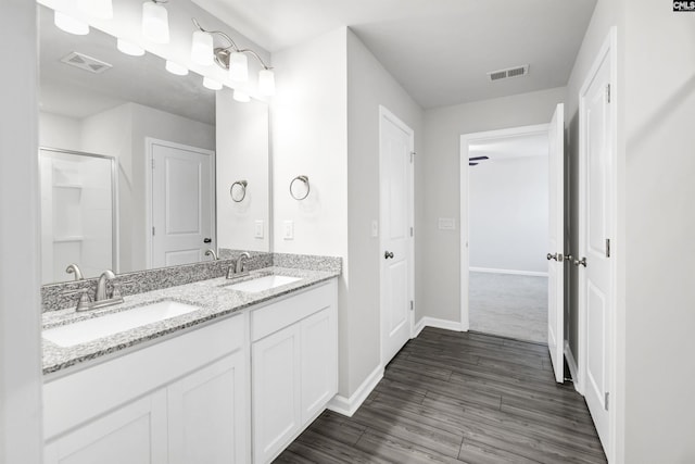 bathroom with hardwood / wood-style floors, an enclosed shower, ceiling fan, and vanity