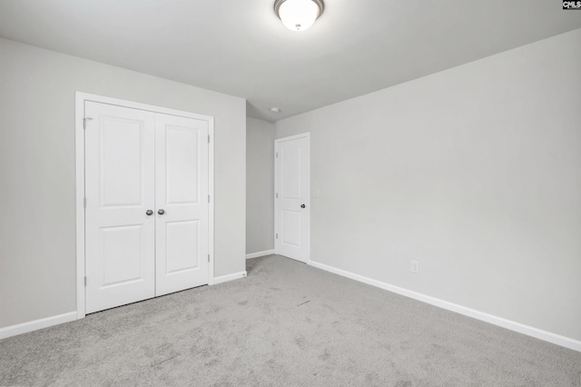 unfurnished bedroom with a closet and light colored carpet