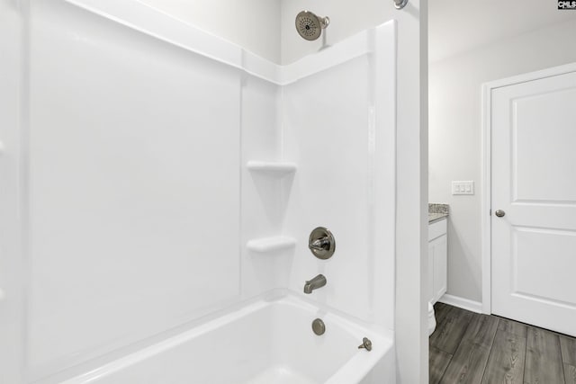 bathroom featuring vanity, hardwood / wood-style flooring, and  shower combination