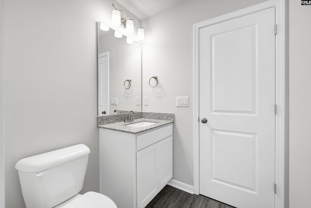 bathroom featuring wood-type flooring, vanity, and toilet