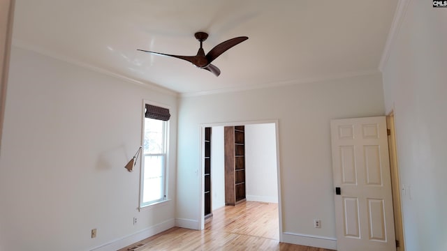 empty room with ceiling fan, ornamental molding, and light wood-type flooring