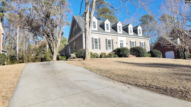 new england style home with a garage and a front lawn