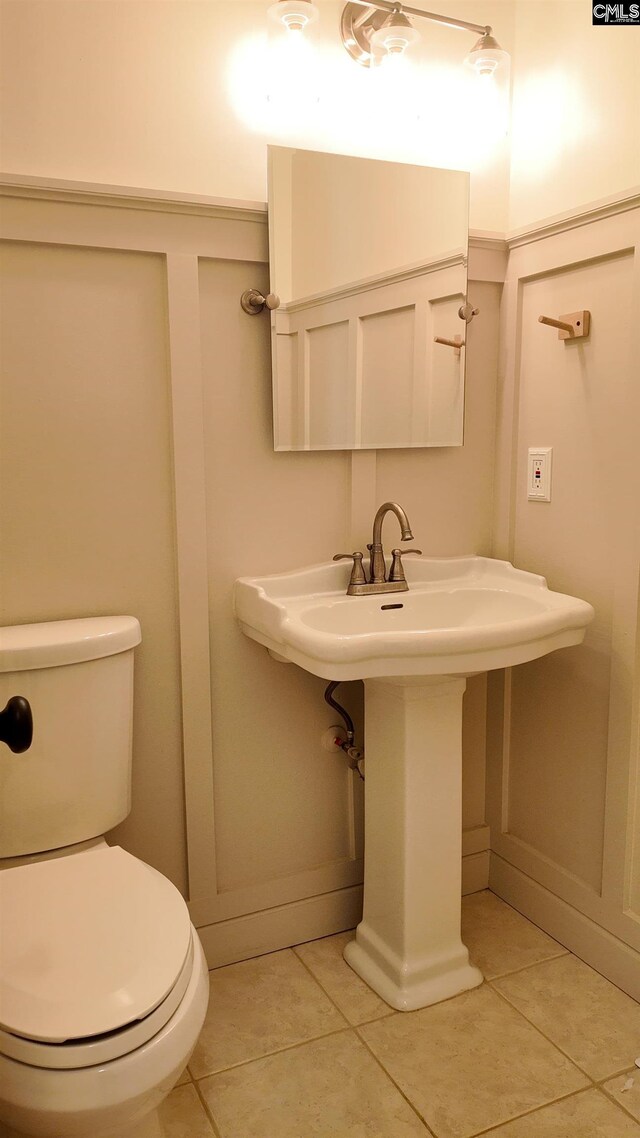 bathroom with sink, toilet, and tile patterned flooring