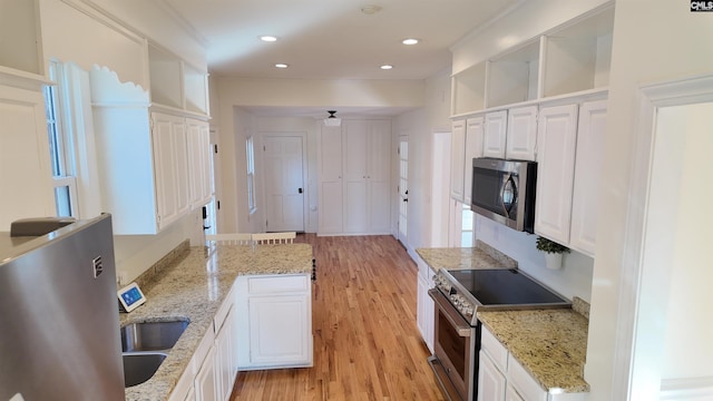 kitchen with light stone counters, white cabinets, and appliances with stainless steel finishes