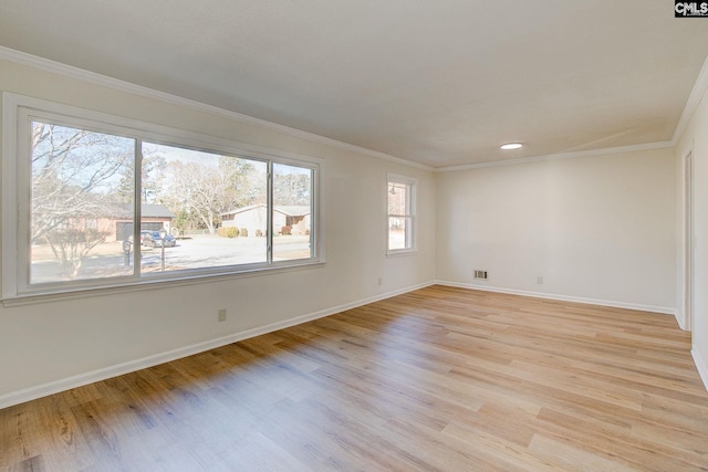 spare room featuring ornamental molding and light hardwood / wood-style flooring