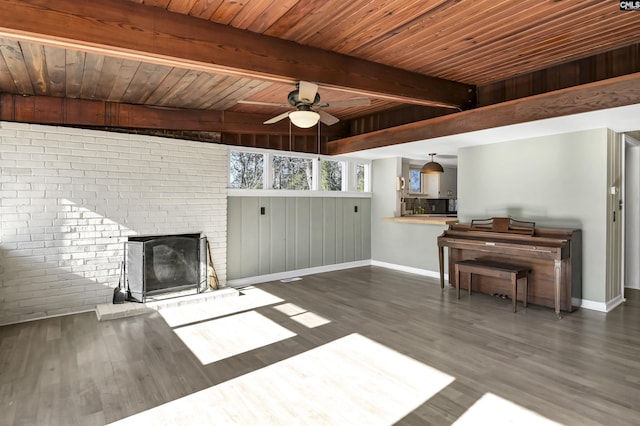 unfurnished living room with wood ceiling, beamed ceiling, ceiling fan, dark wood-type flooring, and a fireplace