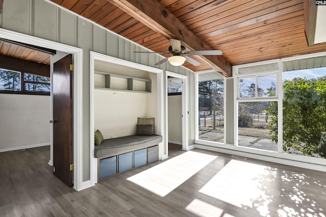 unfurnished sunroom featuring wooden ceiling, ceiling fan, and beamed ceiling