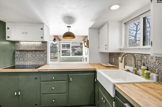 kitchen with decorative light fixtures, white cabinetry, green cabinets, butcher block countertops, and black electric cooktop