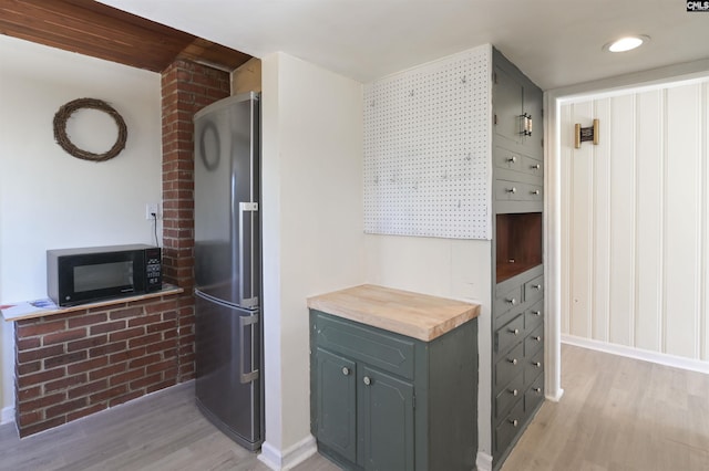 kitchen featuring wooden counters, stainless steel refrigerator, light wood-type flooring, and gray cabinets