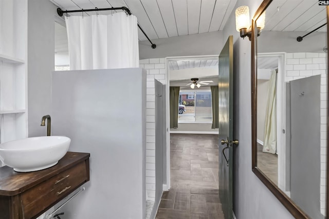 bathroom featuring walk in shower, vanity, ceiling fan, and wood ceiling