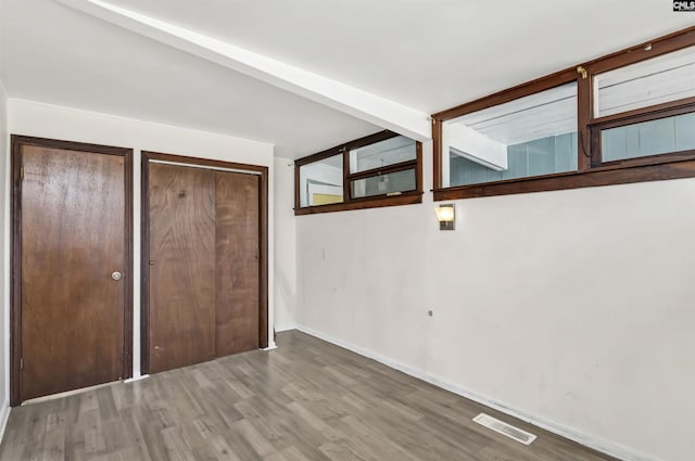 unfurnished bedroom with vaulted ceiling and hardwood / wood-style flooring