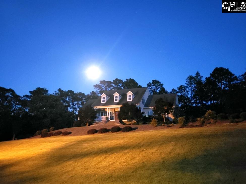 cape cod-style house featuring a lawn