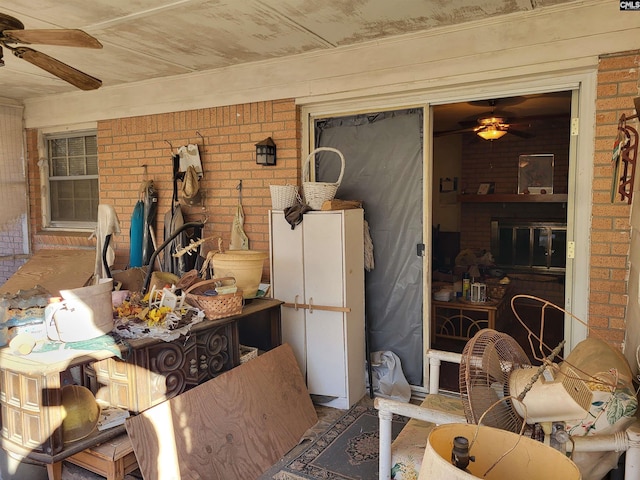 exterior space with brick wall and ceiling fan