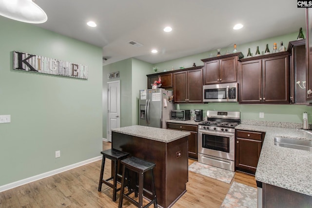 kitchen featuring sink, a kitchen island, light hardwood / wood-style flooring, and appliances with stainless steel finishes