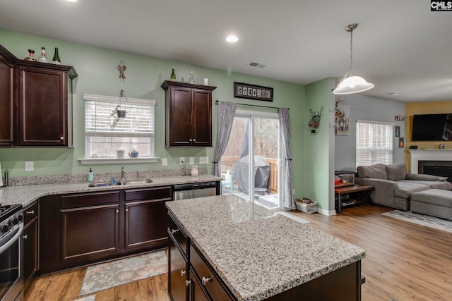 kitchen featuring sink, a healthy amount of sunlight, light hardwood / wood-style floors, and a kitchen island