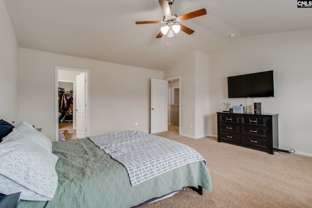 bedroom with vaulted ceiling, a spacious closet, a closet, light colored carpet, and ceiling fan