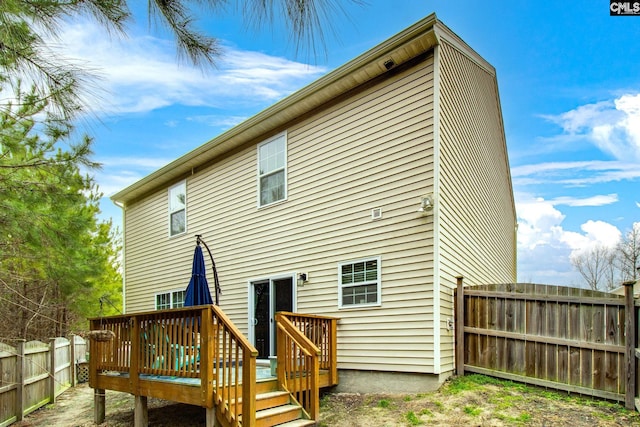 rear view of house featuring a wooden deck