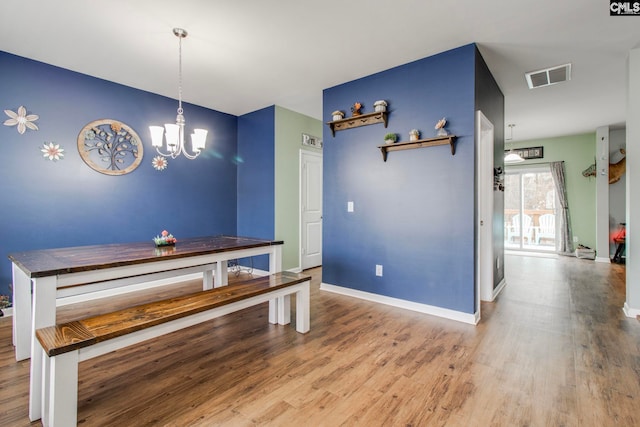 dining room with an inviting chandelier and light hardwood / wood-style flooring