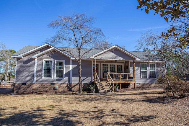 ranch-style house featuring covered porch and a front lawn