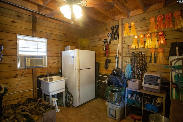 kitchen featuring white fridge, wooden walls, cooling unit, ceiling fan, and beamed ceiling