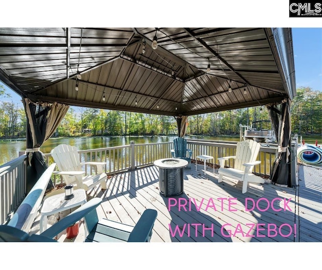 deck featuring a gazebo, a fire pit, and a water view