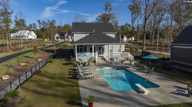 rear view of house featuring a pool side deck, a patio area, and a yard