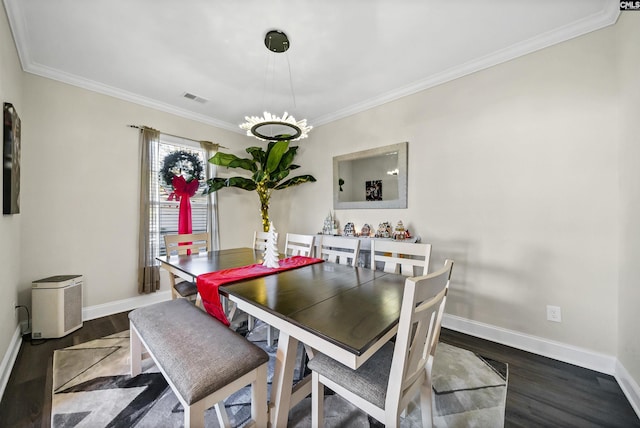 dining room with an inviting chandelier, crown molding, and dark hardwood / wood-style floors