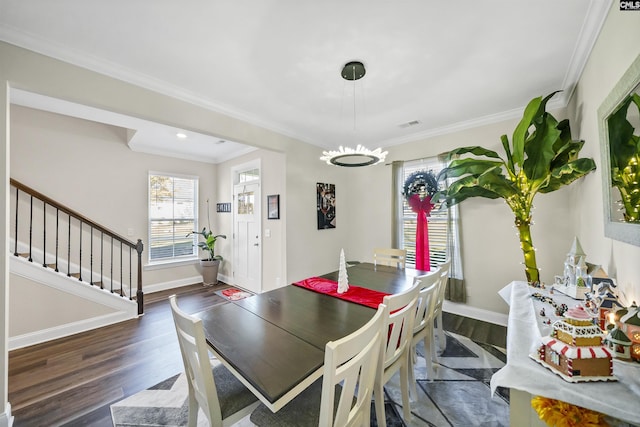 dining space featuring an inviting chandelier, ornamental molding, and dark hardwood / wood-style floors