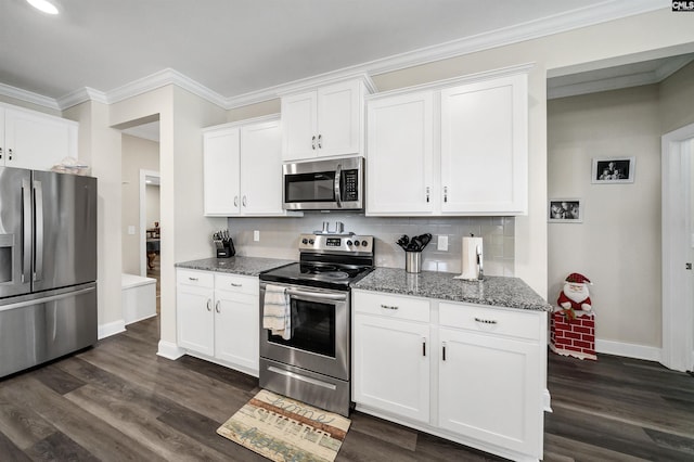 kitchen featuring dark wood-type flooring, stainless steel appliances, tasteful backsplash, white cabinetry, and dark stone counters