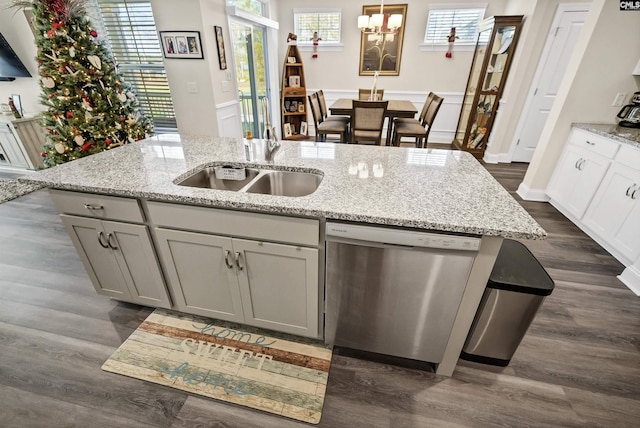 kitchen featuring gray cabinetry, dark hardwood / wood-style flooring, dishwasher, and light stone countertops