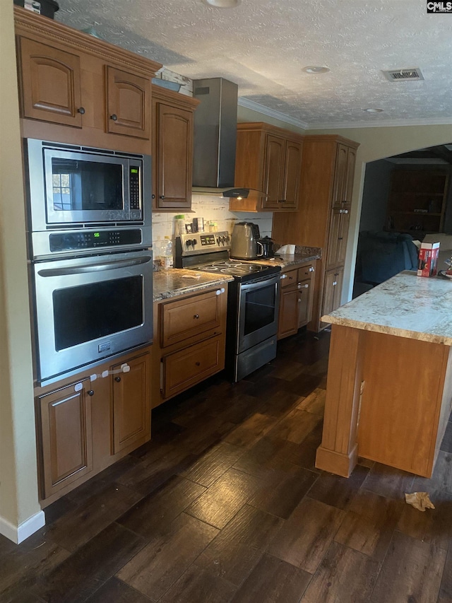 kitchen with a textured ceiling, dark hardwood / wood-style floors, and appliances with stainless steel finishes