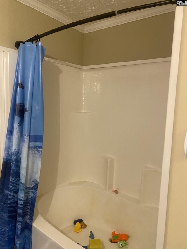 bathroom with shower / bath combination with curtain, a textured ceiling, and crown molding