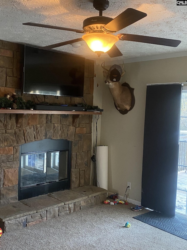 interior details featuring a textured ceiling, ceiling fan, carpet, and a stone fireplace