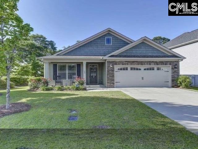 craftsman-style home featuring a porch, a front yard, and a garage