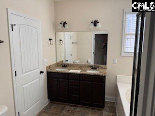 bathroom featuring toilet, vanity, and a bathtub