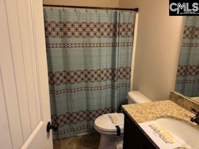 bathroom featuring toilet, a shower with curtain, and vanity