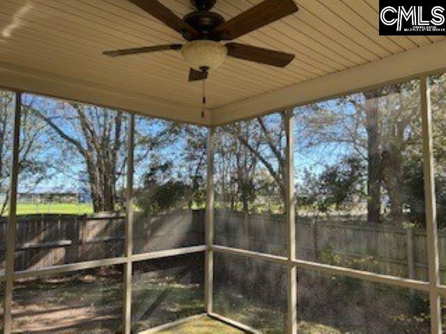 unfurnished sunroom featuring ceiling fan