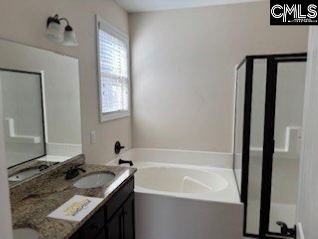 bathroom with vanity and a bath