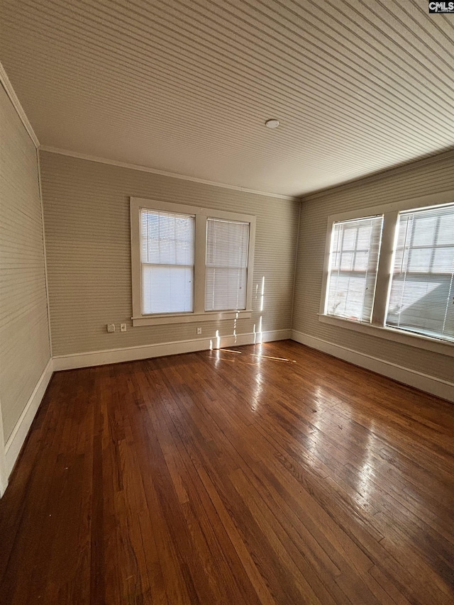 empty room with ornamental molding and wood-type flooring