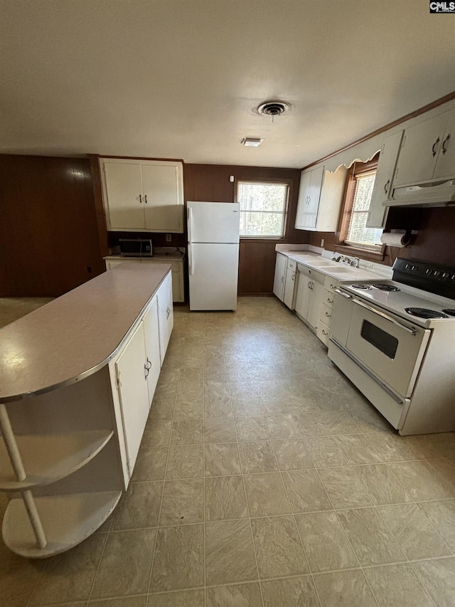 kitchen featuring white appliances, white cabinetry, a center island, and sink