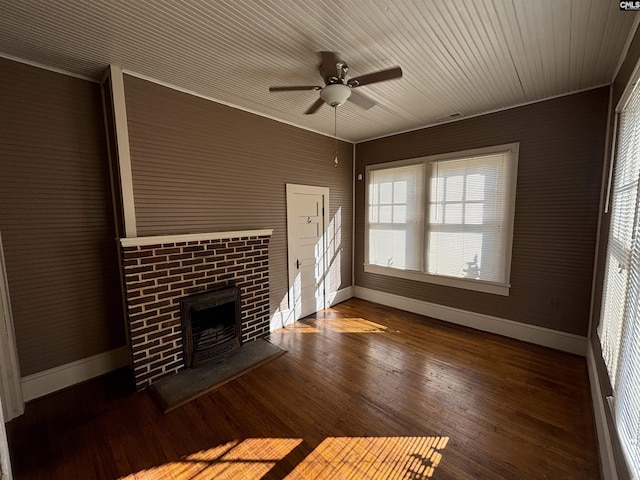 unfurnished living room featuring ceiling fan, dark hardwood / wood-style flooring, a brick fireplace, and ornamental molding