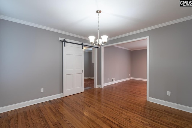 unfurnished room featuring dark wood-type flooring, a notable chandelier, a barn door, and crown molding