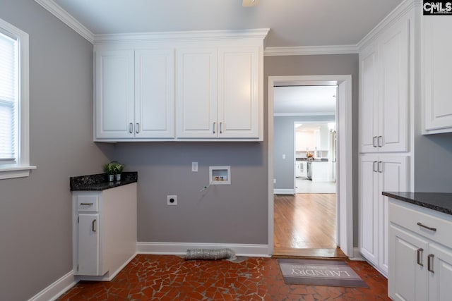 clothes washing area with cabinets, hookup for a washing machine, crown molding, and electric dryer hookup